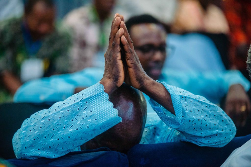 Man praying in a Nigerian church, depicting deep devotion and spirituality.